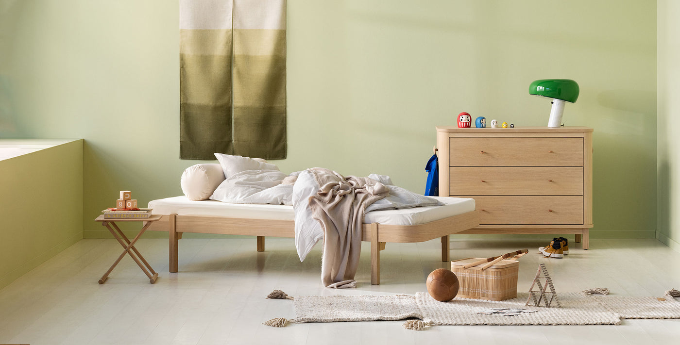 Oliver Furniture Wood lounger and dresser in a styled child's room